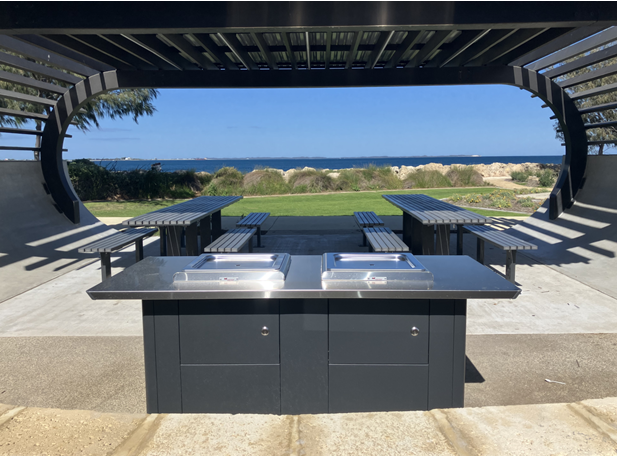 Image of a barbeque installed in a beach location near existing picnic shelters 