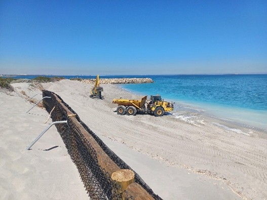 Image of sand nourishment occurring at a beach